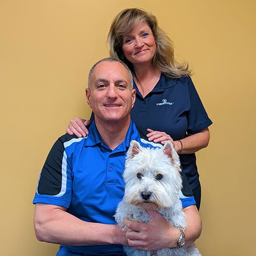 man and woman holding dog